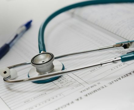 A stethoscope and pen resting on a medical form